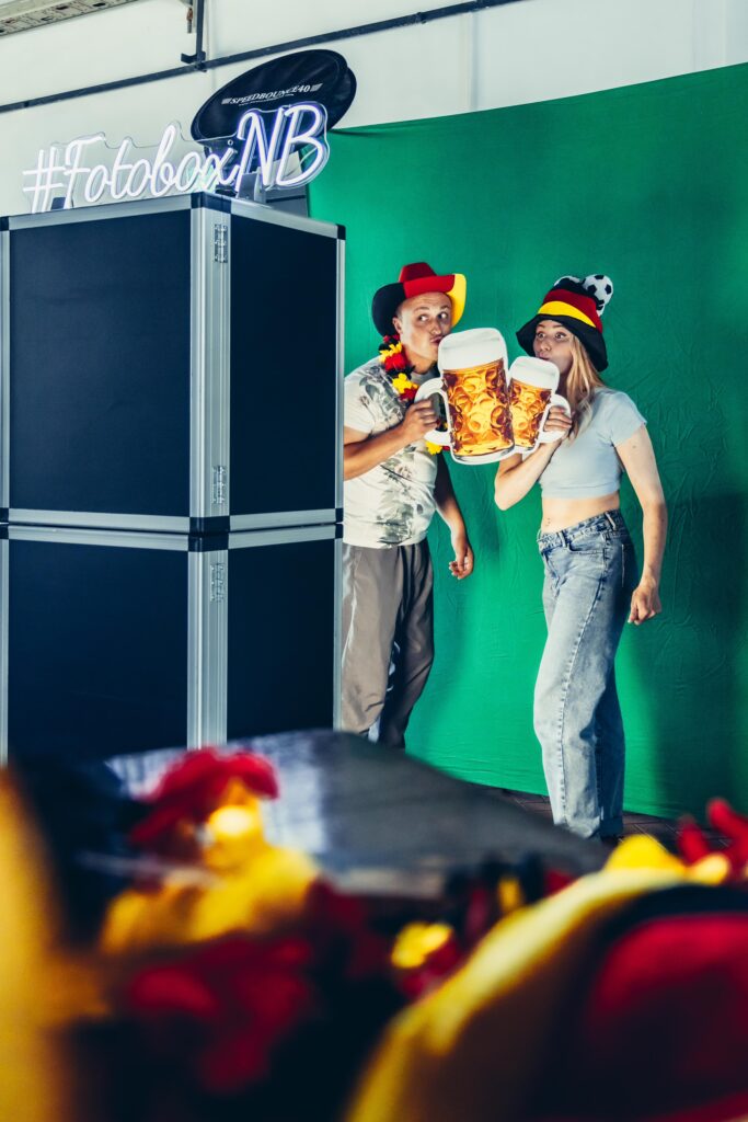 Fotobox Hochzeit: Brautpaar und Gäste nutzen die Fotobox und den Fotospiegel auf einer Hochzeit, um besondere Momente festzuhalten.