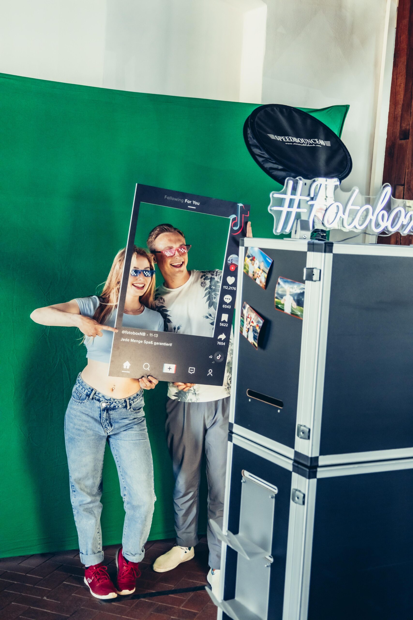 Fotobox Hochzeit: Brautpaar und Gäste nutzen die Fotobox und den Fotospiegel auf einer Hochzeit, um besondere Momente festzuhalten.
